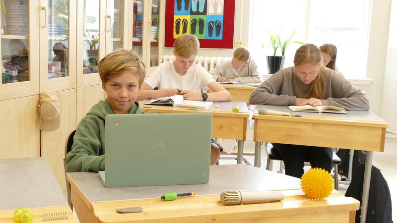 Flera elever sitter i ett klassrum på Kiaby skola.  I förgrunden Sigge Thim och Lukas Langeskär. I bakgrunden Ville Haskå Florell och Moa Hamberg.