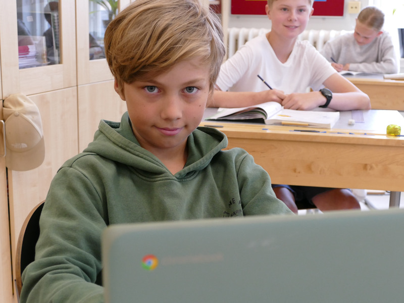 Lukas Langeskär vid sin dator i klassrummet på Kiaby skola. I bakgrunden Ville Haskå Florell.